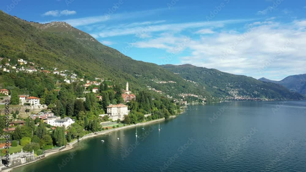 La ville de Baveno entourée des sommets verdoyant sur le lac Majeur vers Stresa, dans le Piémont, en Italie, en drone et à l'été lors d'une journée sous le Soleil. La ville de Baveno entourée des sommets verdoyant sur le lac Majeur vers Stresa, dans le Piémont, en Italie, en drone et à l'été lors d'une journée sous le Soleil.