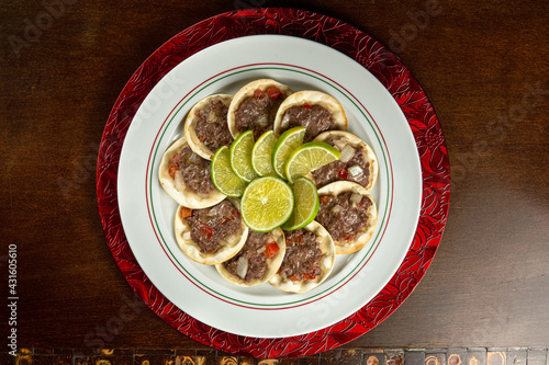 Traditional Middle Eastern food. Lebanese Sfiha meat. Arabian sfeeha plate. Esfiha with lemons on a wood base. Top view
