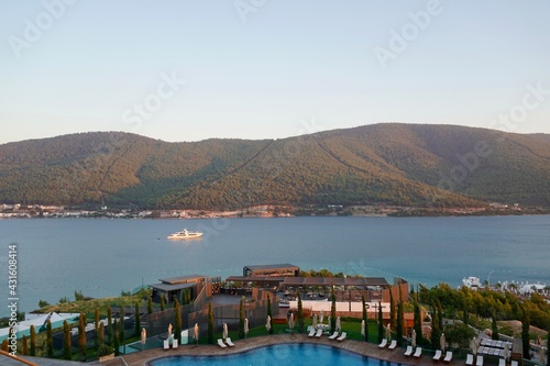 Coast of Turkey, Bodrum. Tourist yacht in beautiful emerald-blue sea. Blue sea water pools in the foreground, tropical nature. Landscape, view of Aegean Sea. Tourism (travel) to Bodrum Turkey
