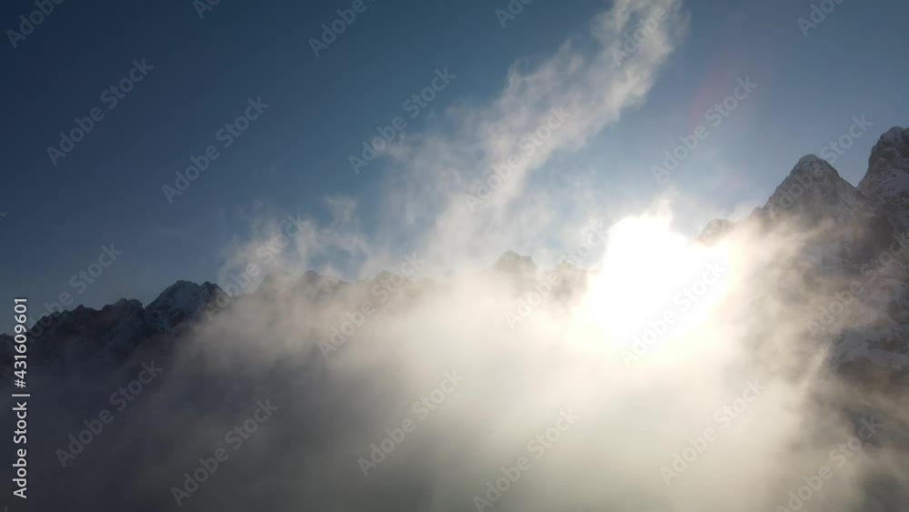 Drone flight through clouds against sun and mountains , Alps, Vrsic Pass, Slovenia Drone flight through clouds against sun and mountains , Alps, Vrsic Pass, Slovenia