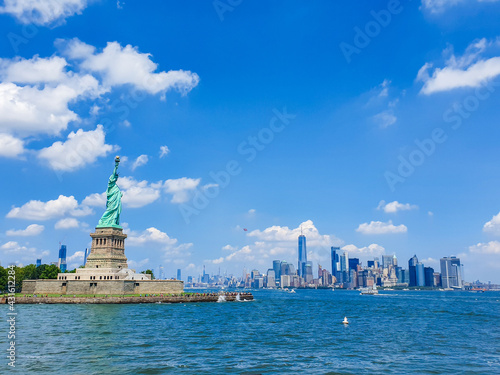 Iconic New York City view from Staten Island ferry over Statue of liberty and lower Manhattan.