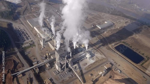 Smoke Coming Out On Chimneys Of Pulp And Paper Mill At Quesnel City, BC, Canada. - aerial photo