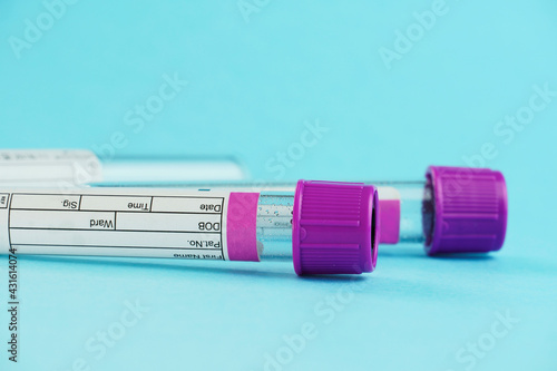 vacuum tubes for collection and blood samples on blue background..Transparent with purple and green lid. Label to identify the data. Selective focus. photo