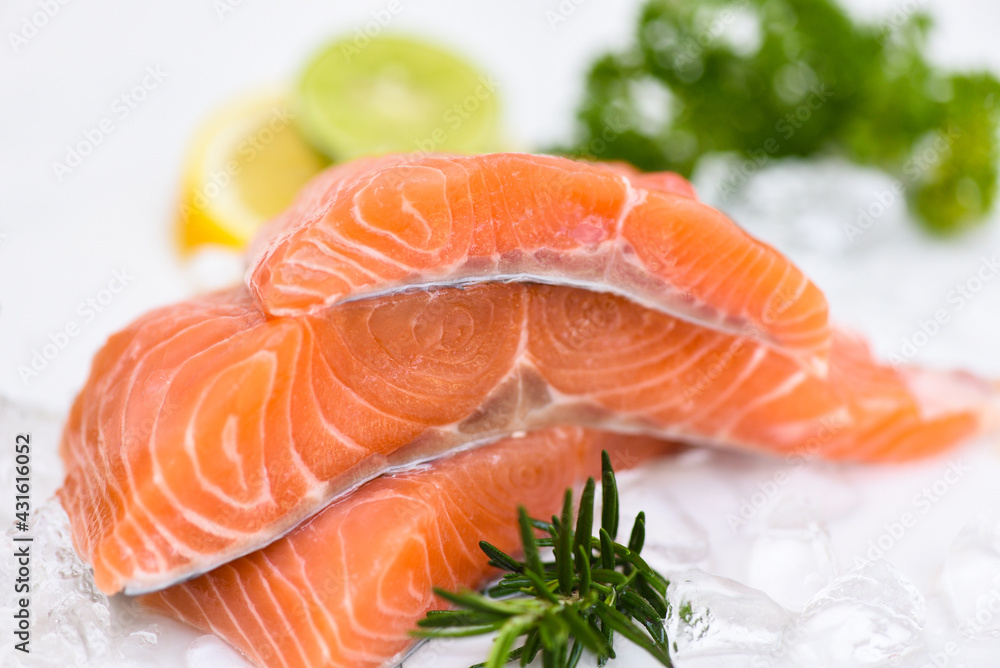 Raw salmon filet with herbs and spices on white background, Fresh salmon fish on ice Raw salmon filet with herbs and spices on white background, Fresh salmon fish on ice