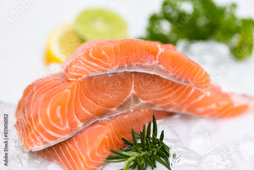 Raw salmon filet with herbs and spices on white background, Fresh salmon fish on ice