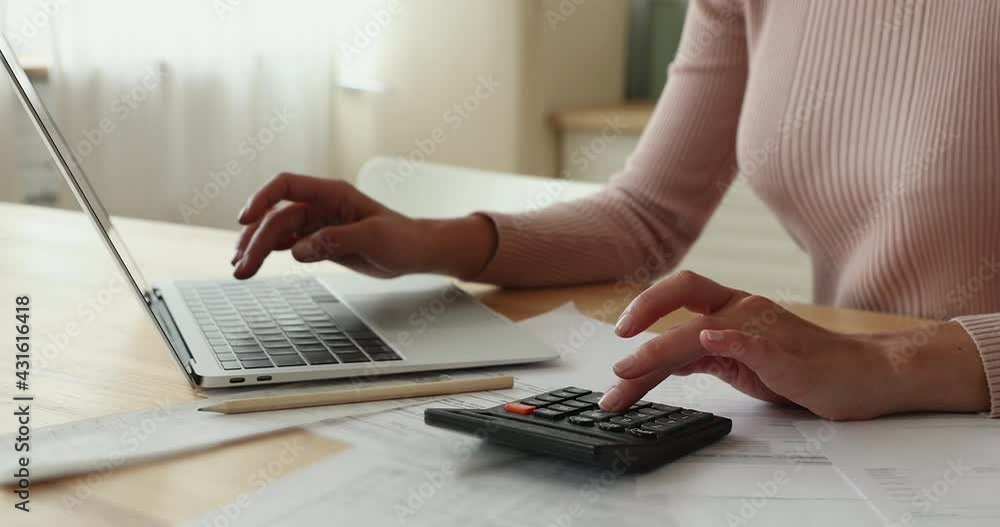 Close up view female hands use calculator laptop calculates costs working sit at table. Pay monthly bills through e-bank app. Business, summarize household expenses, manage budget, accounting concept Close up view female hands use calculator laptop calculates costs working sit at table. Pay monthly bills through e-bank app. Business, summarize household expenses, manage budget, accounting concept