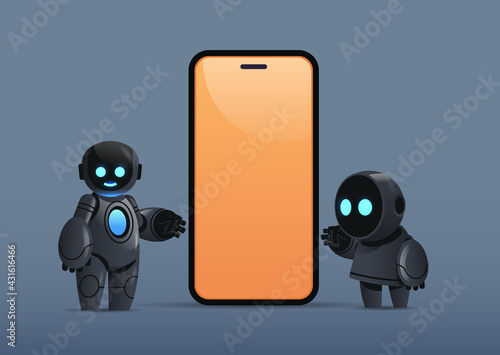 two robots standing near smartphone with blank screen robotic character artificial intelligence technology concept