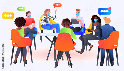 mix race businesspeople in masks discussing during meeting at round table chat bubble communication concept