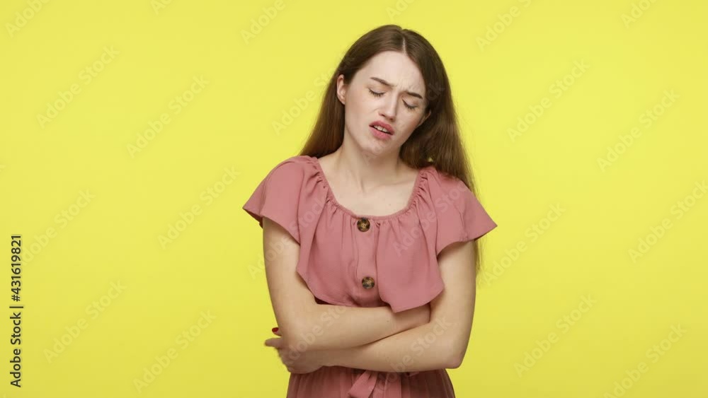 Depressed young woman rubbing painful belly, suffering stomach ache, miscarriage, menstrual cramps in abdomen, constipation and period problems. Indoor studio shot isolated on yellow background. Depressed young woman rubbing painful belly, suffering stomach ache, miscarriage, menstrual cramps in abdomen, constipation and period problems. Indoor studio shot isolated on yellow background.