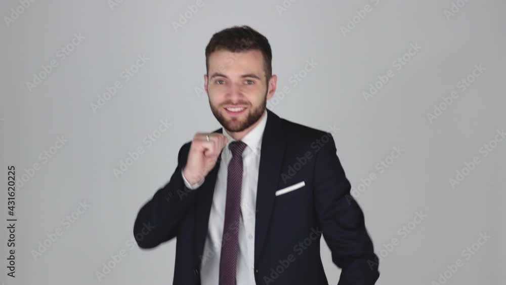 Young Handsome Businessman in suit tired but dancing with joy, isolated on grey background Young Handsome Businessman in suit tired but dancing with joy, isolated on grey background