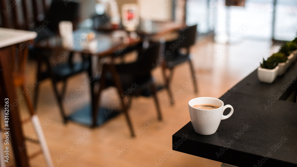 White coffee mug on the table inside the cafe