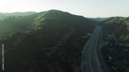 Aerial Panning Shot Of Traffic On Highway By Near Famous Getty Center, Drone Flying Forward Over Vehicles Against Sky At Sunset - Los Angeles, California photo