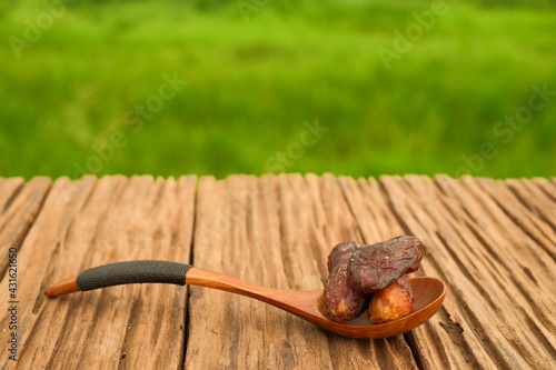 Dried dates with and wooden spoon on oldwooden table photo