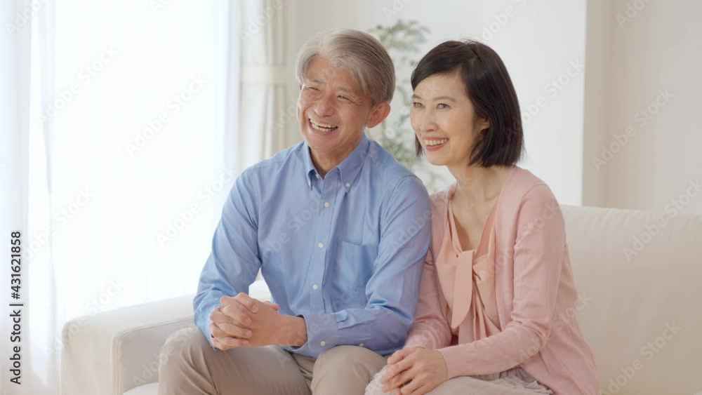 リビングで映画を鑑賞するミドル夫婦 リビングで映画を鑑賞するミドル夫婦