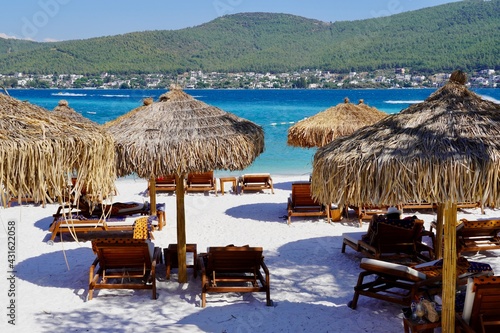 Bodrum  Turkey - August  2020 Snow-white beach of Lux Hotel with emerald water of Aegean Sea. Yachts. People sunbathing on the beach. Sunbeds on the beach. Relaxing Deluxe Leisure Conception. Paradise