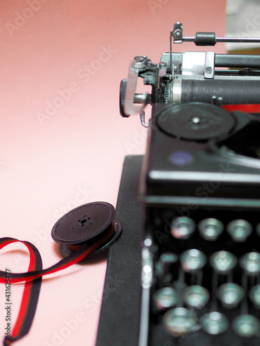 Vertical shot of a teleprinter and a red ribbon on a table photo