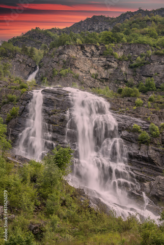 beautiful waterfalls with crystal clear water with mountains in the background at sunset Norway.