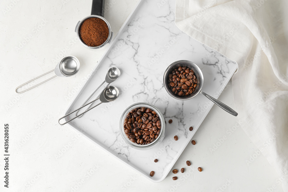 Jar and pot with coffee beans on light background - obrazy, fototapety, plakaty 