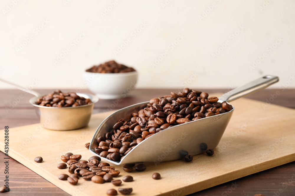 Scoop and pot with coffee beans on wooden background - obrazy, fototapety, plakaty 