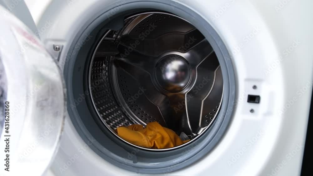 Woman's hand Pick up clothes Washing machine.Clean and Healthy Concepts. Woman's hand Pick up clothes Washing machine.Clean and Healthy Concepts.