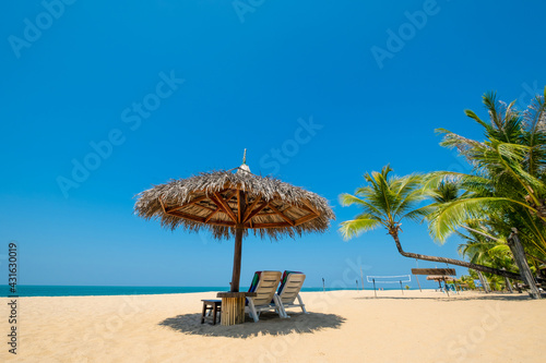 Beach chairs, umbrella and palms on sandy beach near sea. island in Phuket, Thailand. Travel inspirational, Summer holiday and vacation concept for tourism relaxing.. © jakkapan