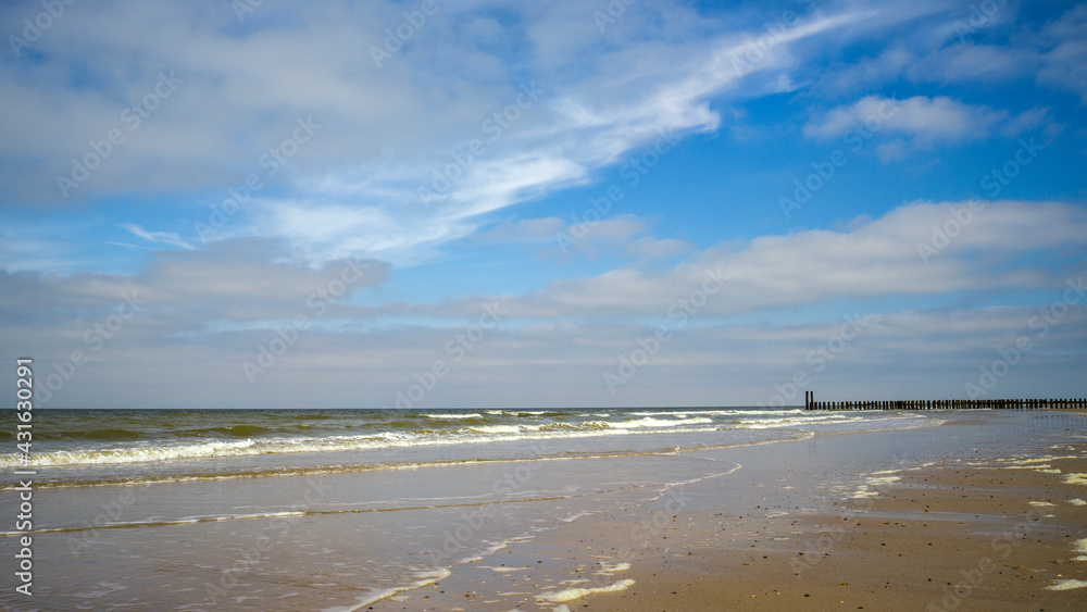 ein breiter Sandstrand vor bewölktem blauem Himmel ein breiter Sandstrand vor bewölktem blauem Himmel