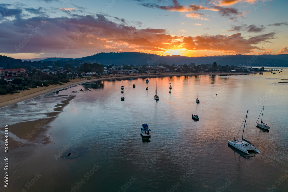 Fototapeta premium Aerial sunrise waterscape with boats and cloud cover