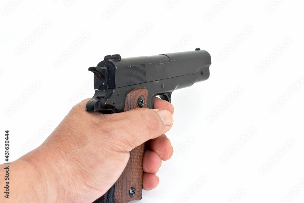 The brown-black handgun is in the hand of the shooter shooting on a white background. 