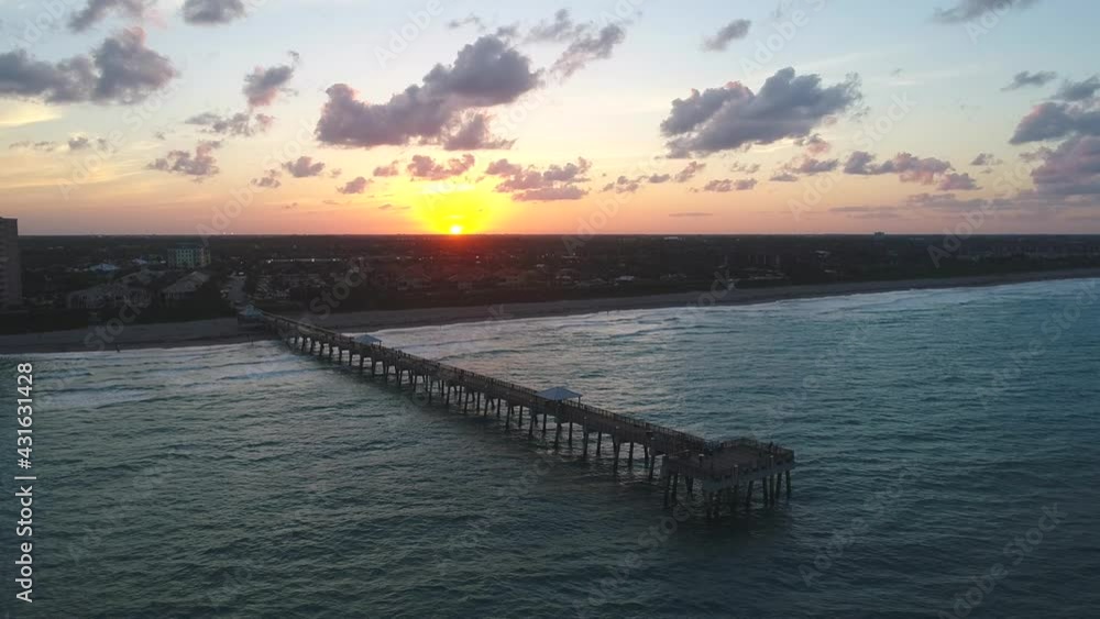 This is an aerial Jib Shot of a pier on the beach at sunset or sunrise. This is an aerial Jib Shot of a pier on the beach at sunset or sunrise.