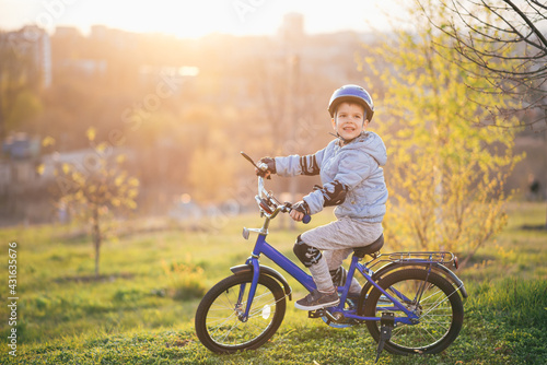 Little boy in helmet rides a bicycle on a sunny day © johnalexandr