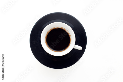A cup of espresso coffee on an old vinyl record on a white background. Coffee break 