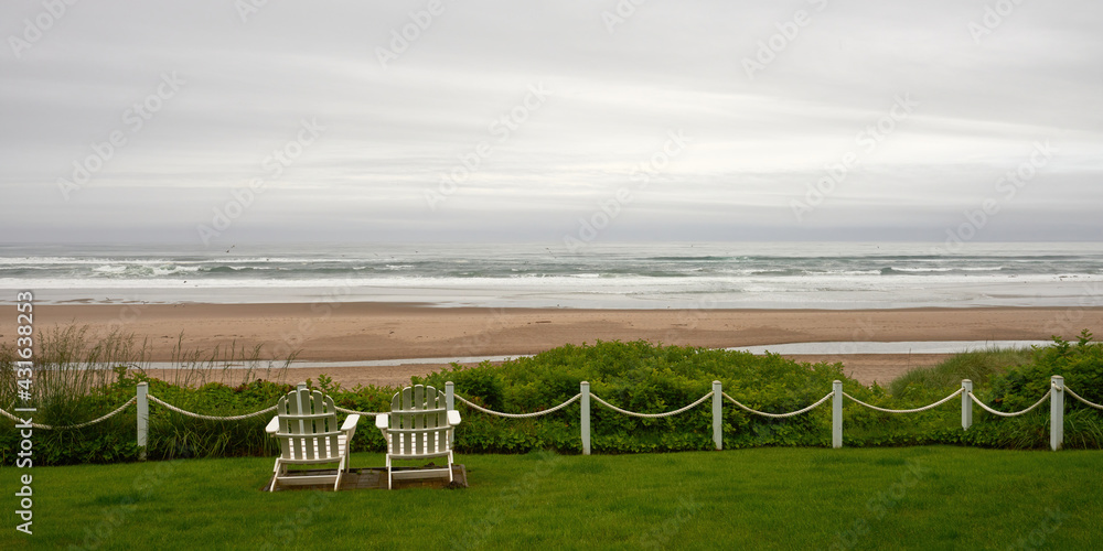 View with two armchairs for relaxing on the coast of the Pacific Ocean on a rainy day on the beach near Lincoln City in Oregon.