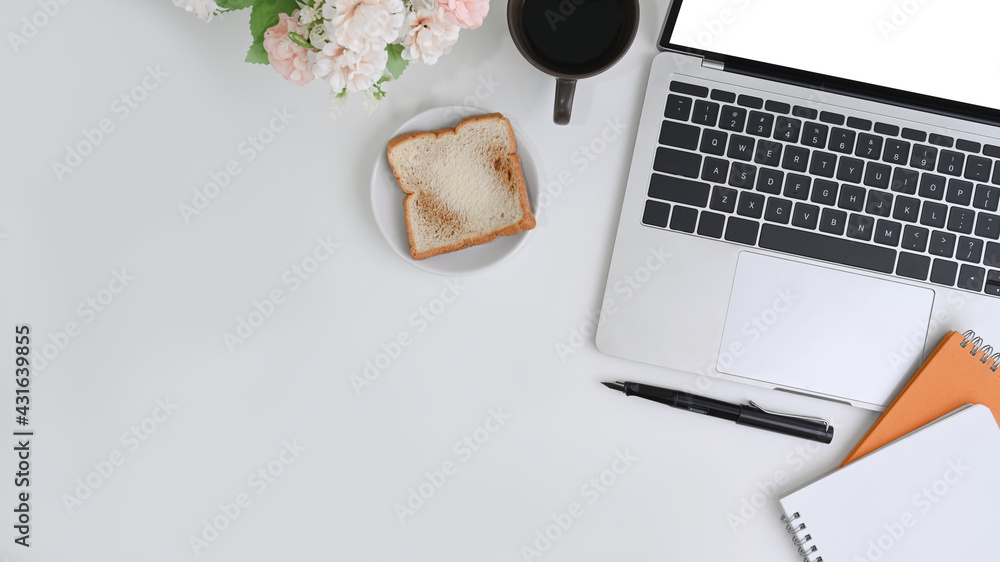 Above view white office desk with laptop computer, notebook,.bread and coffee cup. Above view white office desk with laptop computer, notebook,.bread and coffee cup.
