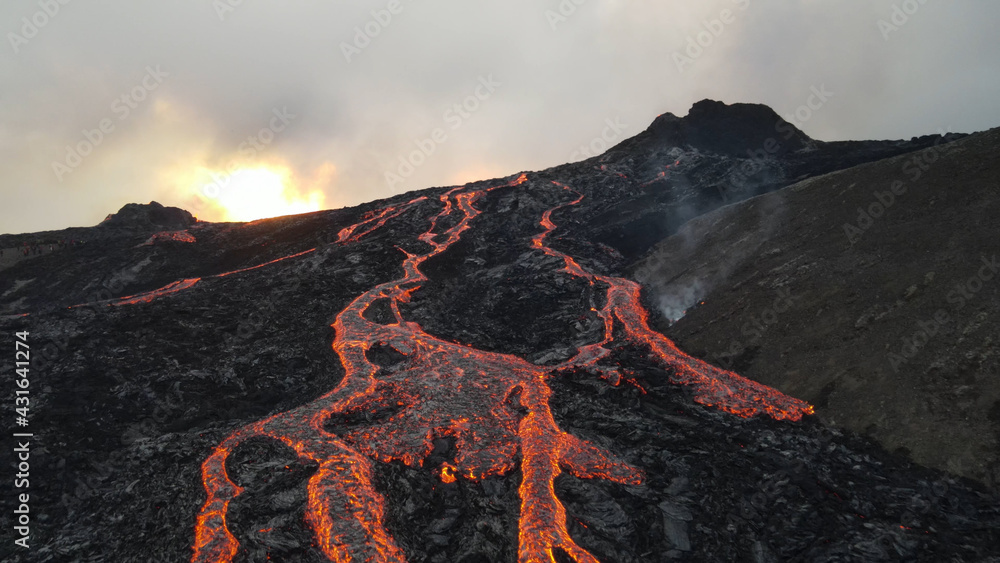 Naklejka premium lava eruption volcano with snowy mountains, Aerial view Hot lava and magma coming out of the crater, April 2021 