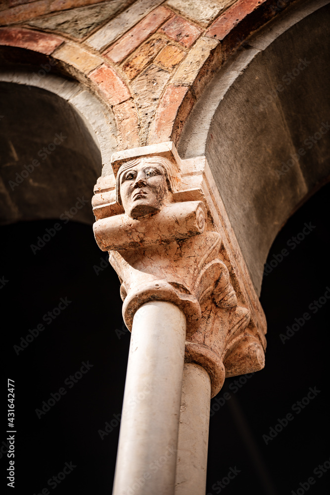 Ancient columns with capitals in the shape of a human head, cloister of the Basilica of Santo Stefano also known by the name of the Seven Churches, Bologna, Emilia-Romagna, Italy, Europe