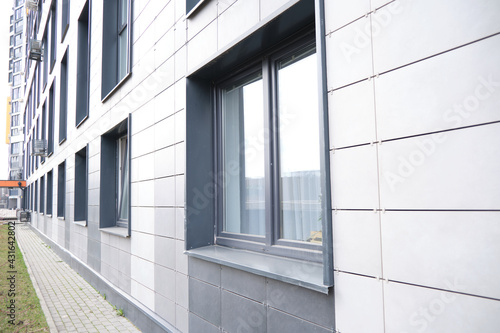 wall of office building made of metal plates with windows. Detail of modern residential building windows on ceramic ventilated facade. photo