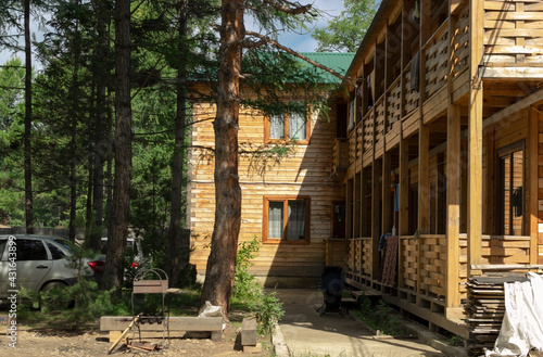 Courtyard of wooden house in countryside forest, traditional rest in cozy rural cabin, concept of unity with nature
