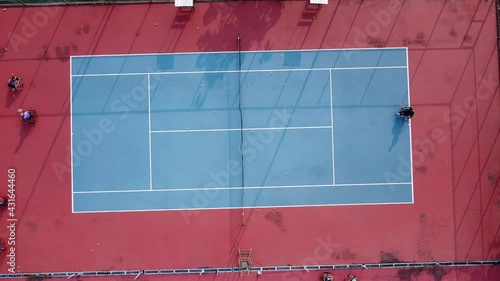 People in wheelchair playing tennis on court. Wheel Chair Tennis For Disabled. Aerial drone footage photo