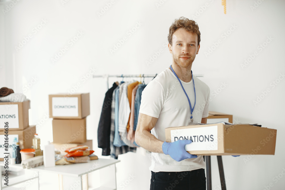 Volunteer guy packs boxes with a humanitarian help Volunteer guy packs boxes with a humanitarian help