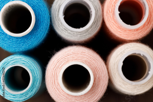 Close up of colored thread coils, thread spools background