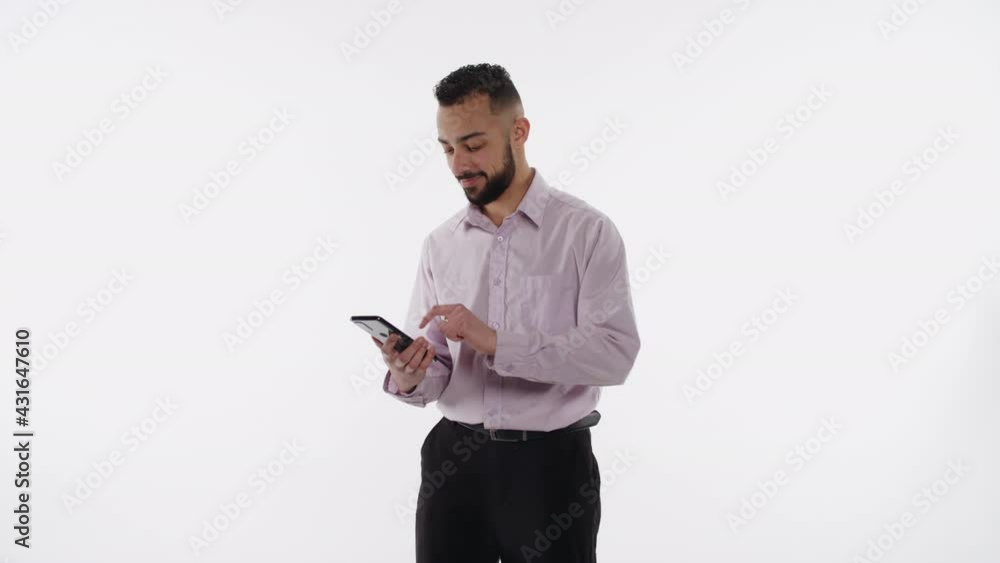 Handsome young professional swipes on smartphone and nods Handsome young professional swipes on smartphone and nods