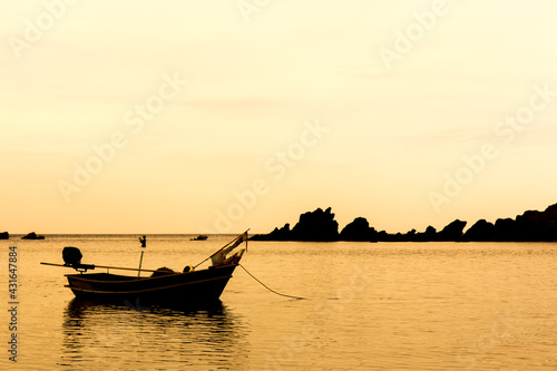  Summer day. Sunset streams through the clouds with fishing boat waves blow to the beach.