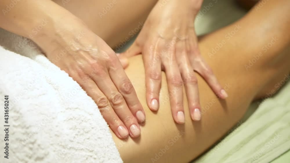 Masseuse working in a spa, female hands giving a leg massage. Giving relax to the muscles of the upper leg, releasing the tension, and the trigger points Masseuse working in a spa, female hands giving a leg massage. Giving relax to the muscles of the upper leg, releasing the tension, and the trigger points