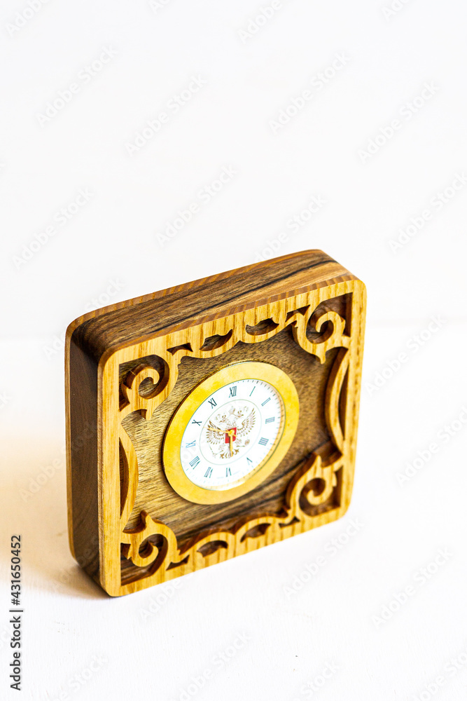 handmade wooden clock with patterns and the emblem of Russia on a white background handmade wooden clock with patterns and the emblem of Russia on a white background