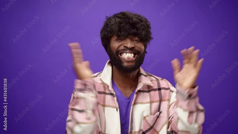 Casual african american man applauding against purple background Casual african american man applauding against purple background