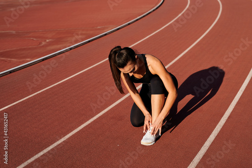 sportswoman in the stadium laces up her laces