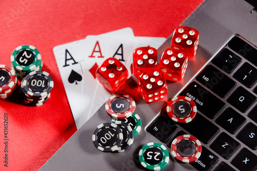 Red playing dice, gambling chips and cards with aces. Online casino theme