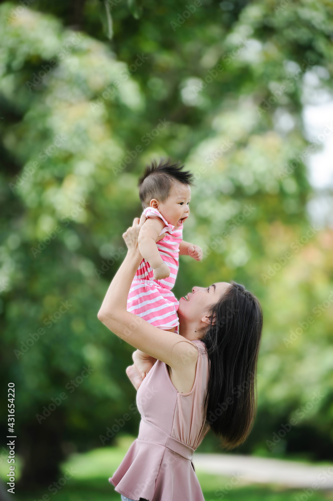 Fototapeta premium Mother and cute baby having fun in nature park