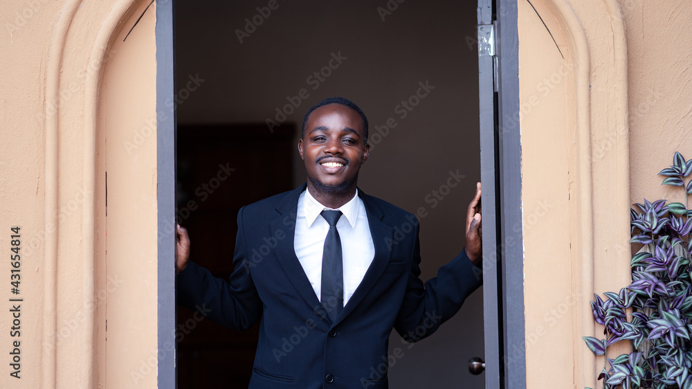 Friendly african businessman standing with open the doors Friendly african businessman standing with open the doors