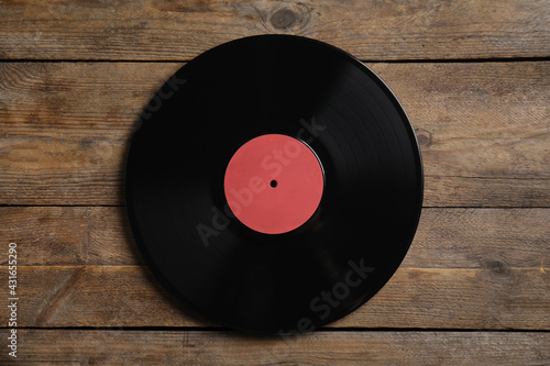 Vintage vinyl record on wooden background, top view